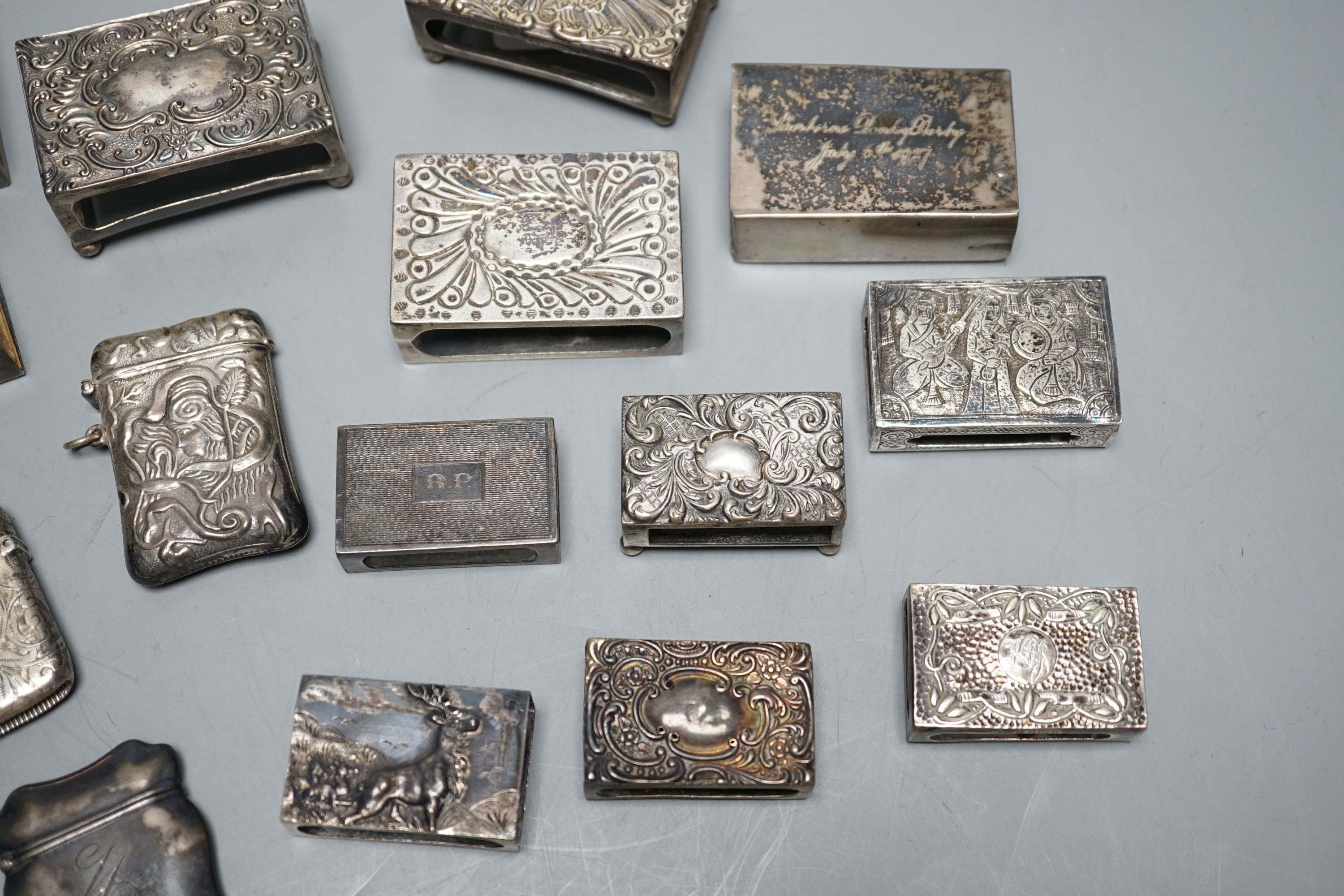 A small collection of nine mainly early 20th century silver or sterling vesta cases, largest 60mm and fourteen assorted similar silver or white metal match sleeves
